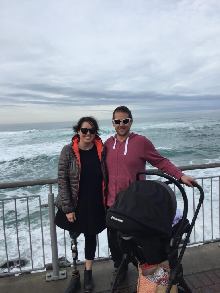 Adam and Elista Hall stand with a baby stroller at a scenic location.