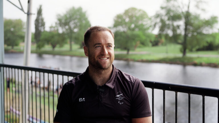 Scott Martlew smiles while sitting next to the Avon River.