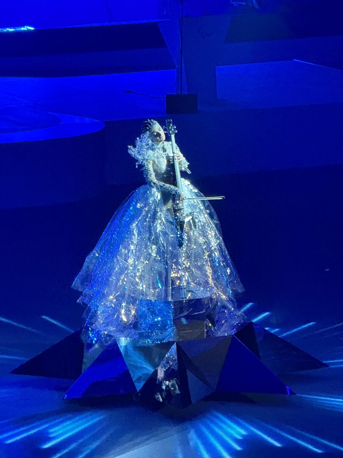 A lady in elaborate dress playing an electric cello