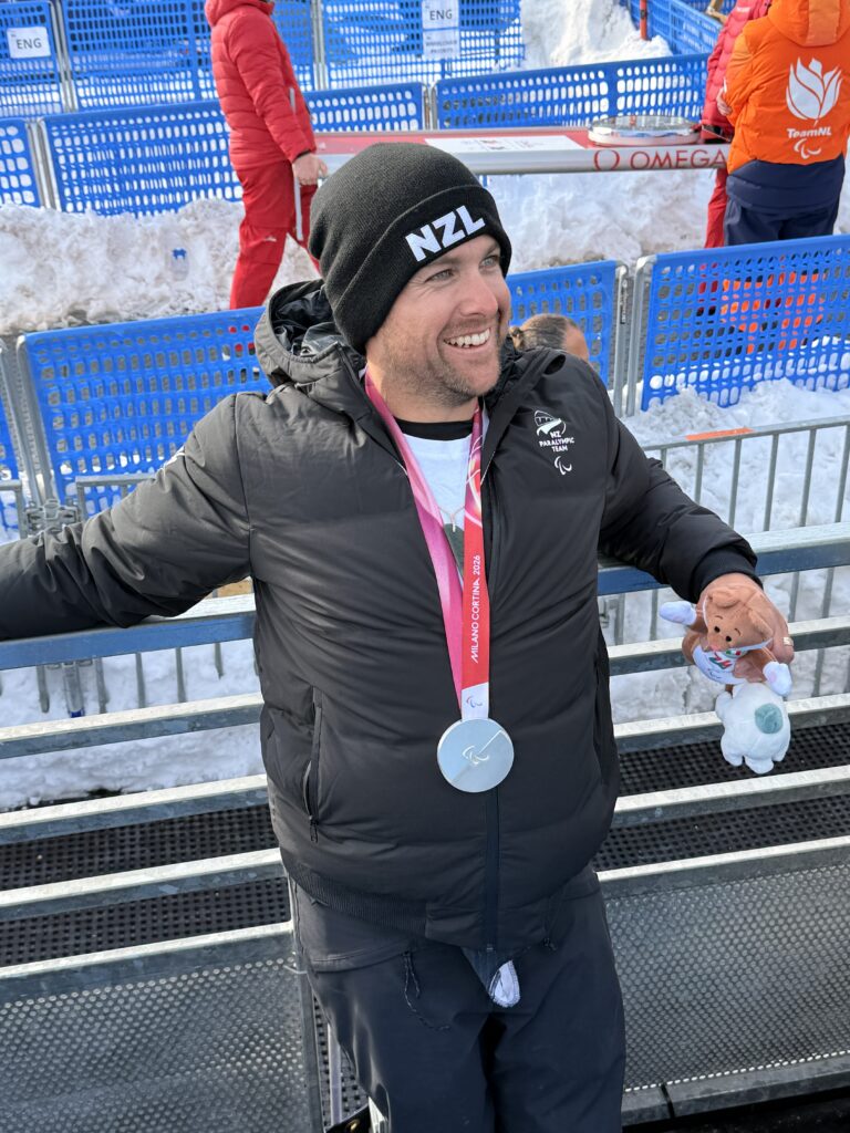 man smiling broadly with medal around his neck