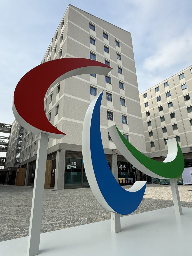 The Paralympic Agitos symbol in front of tall buildings