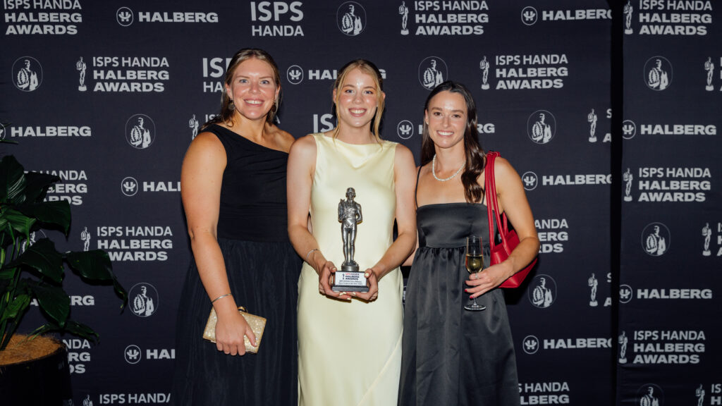 Danielle holds a Halberg award, with two women either side of her. 