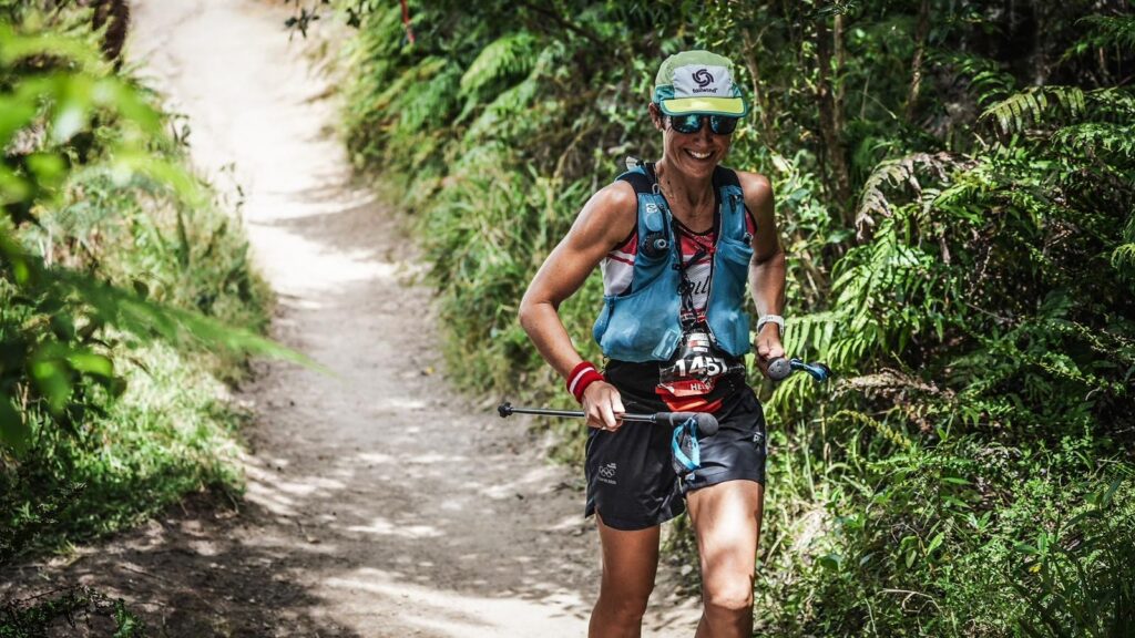 Helene runs on a trail surrounded by NZ bush.