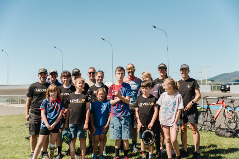 Nelson cycling club stand for a photo together at the outdoor velodrome.