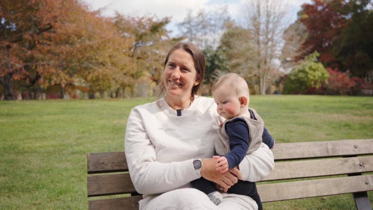 Anna Taylor sits on a park bench holding her 6-month-old Henry