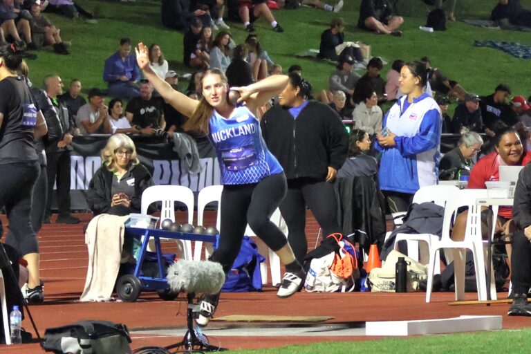 Charli Gardiner-Hall throws a shotput at a competition.