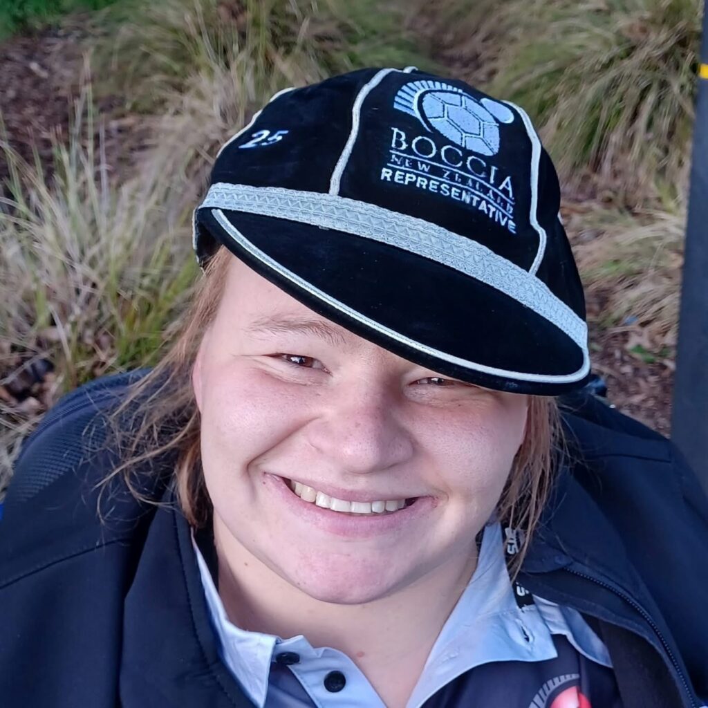 Chloe smiles as she wears her international representative cap from Boccia New Zealand.