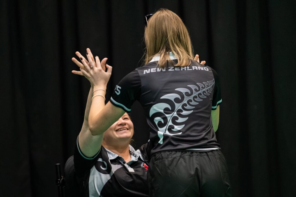 Chloe high-fives a team mate at a Boccia competition. 