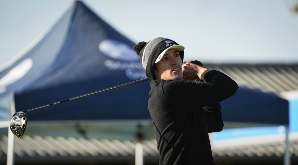 Guy completes a golf swing as he watches the ball fly away.