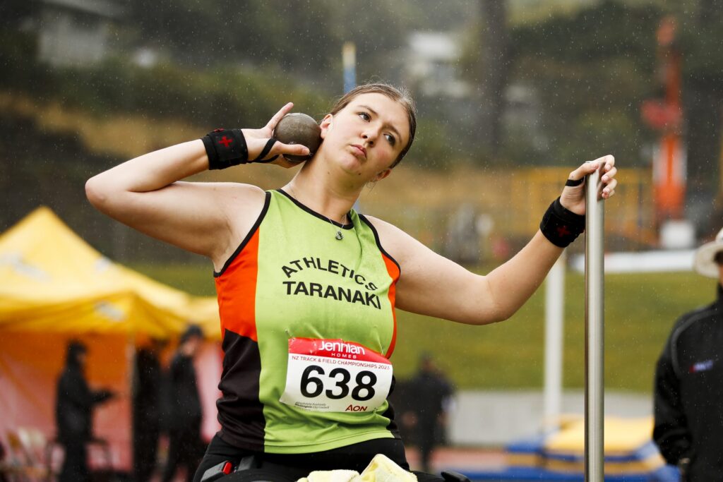 Milly-Marshall Kirkwood throws a shot put while using a throwing frame.