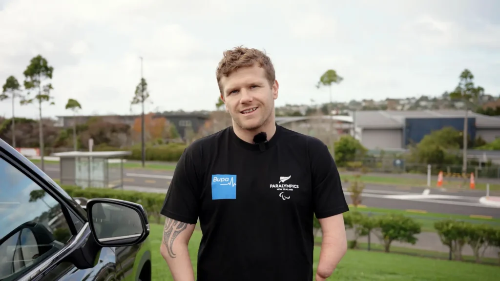 Cameron Leslie smiles while wearing a PNZ Bupa t-shirt.