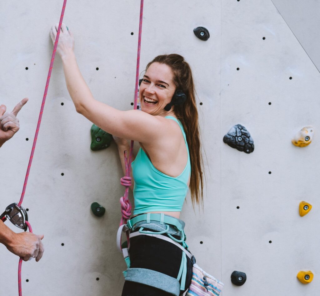 Rachel Maia climbs a rock climbing wall.