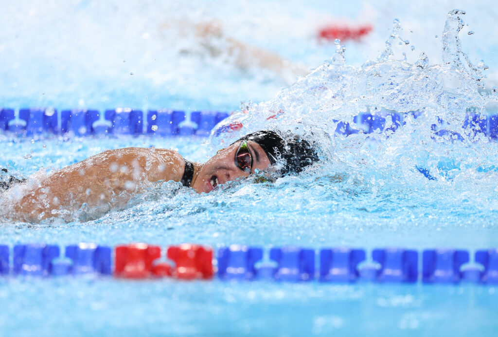 Tupou swims through the water and tilts her head to the side to breath.