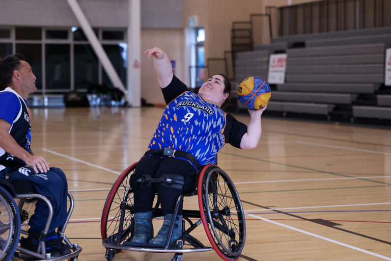 Daniella Egle-Bast throws a basketball during a game of Wheelchair Basketball.