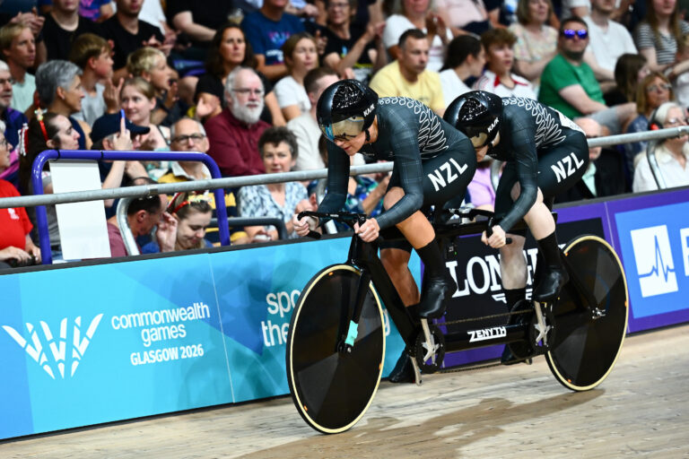 Pilot Jessie Hodges and Paralympian #194 Emma Foy are all dressed in the black of New Zealand riding on a tandem on the velodrome at the Glasgow 2026 Commonwealth Games,