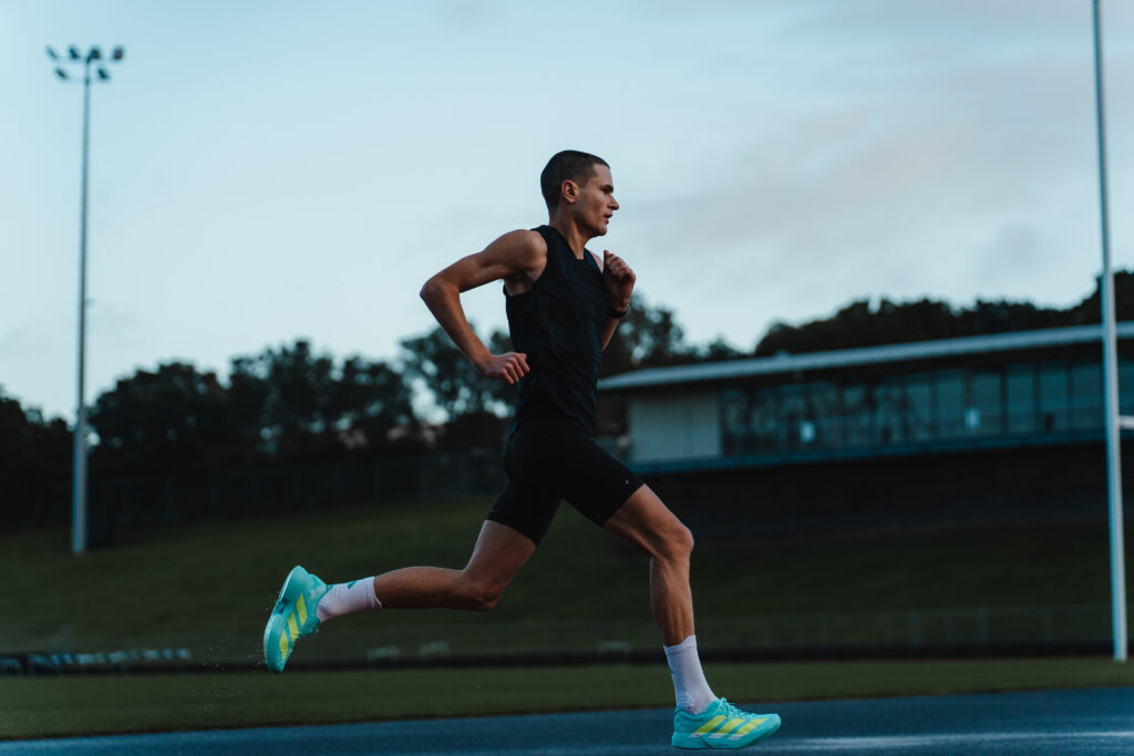 Michael Whittaker runs on an athletics track.