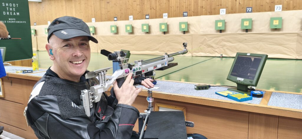 Michael Johnson smiling with his rifle in hand at the Changwon 2026 WSPS World Championships.