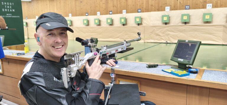 Michael Johnson smiling with his rifle in hand at the Changwon 2026 WSPS World Championships.