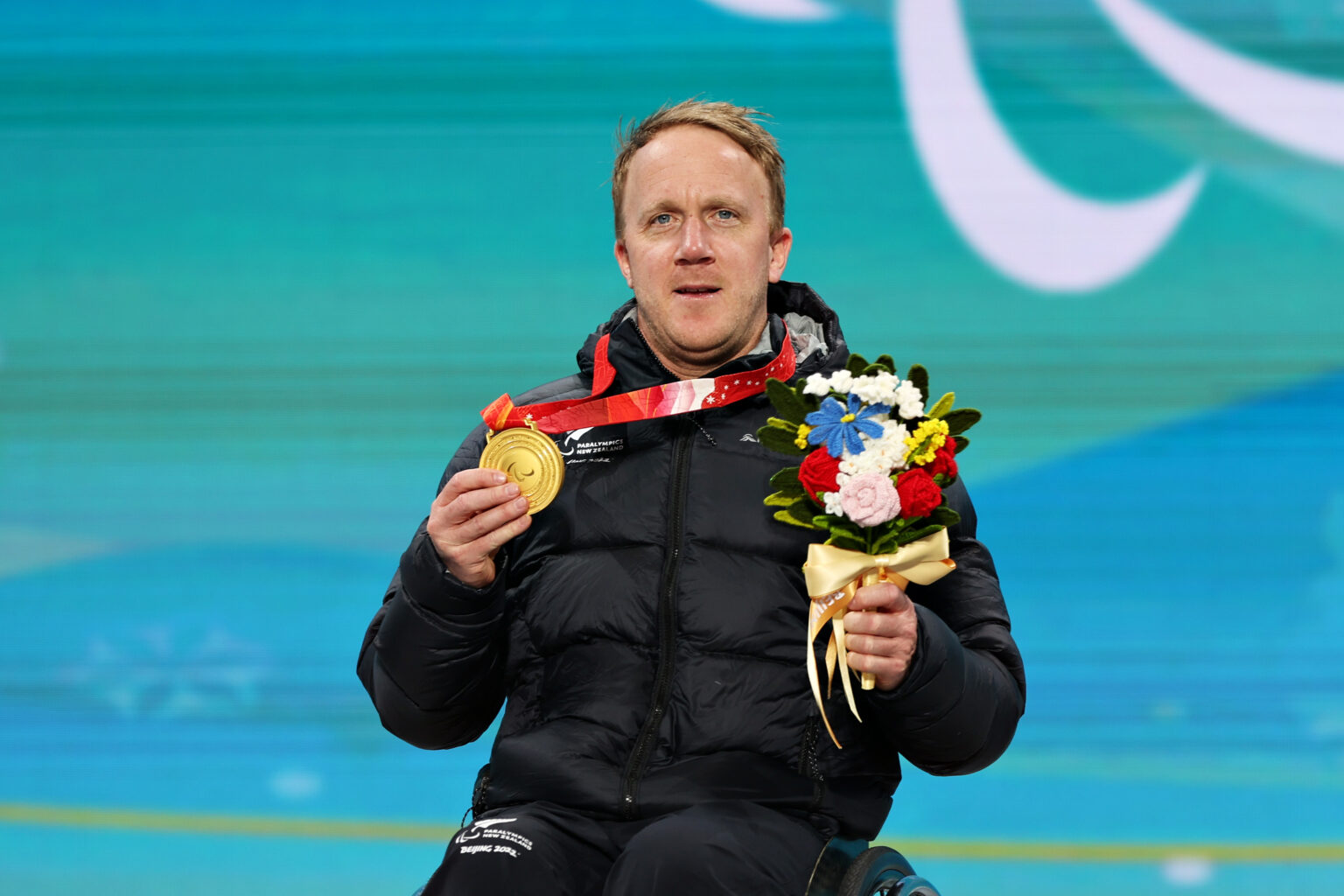 Corey Peters pictured with his sitting downhill gold medal at the 2022 Beijing Paralympic Winter Games.